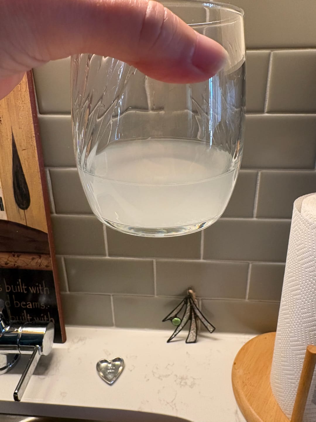 Glass of cloudy water after one cleaning cycle - customer photo from Mara K.